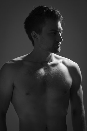 Sexual muscular man posing over dark backgroundの写真素材