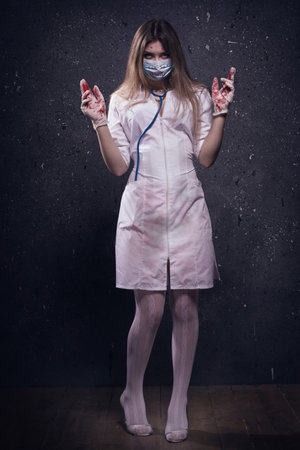Crazy bloody nurse in a dark roomの写真素材