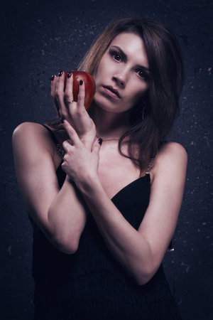 Asylum. Lonely mad woman with red apple. Low key.の写真素材