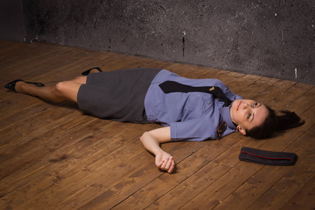 Crime scene imitation. Woman police officer lying on a floorの写真素材