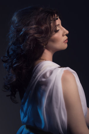 Beautiful Woman Wearing White Greek Toga on a dark backgroundの写真素材