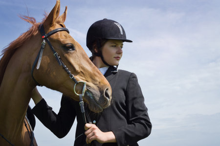 Beautiful young girl jockey with her horse dressing uniform competitionの写真素材
