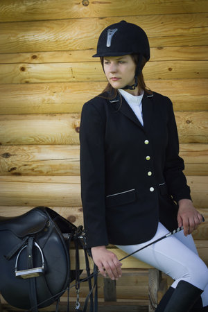 Beautiful girl jockey dressing uniform posing outdoorsの写真素材