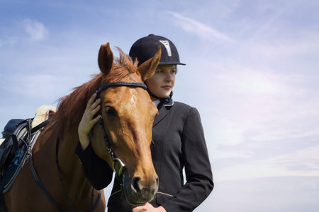 Beautiful young girl jockey with her horse dressing uniform competitionの写真素材
