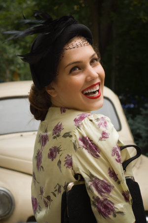Beautiful lady in vintage dress standing near retro carの写真素材