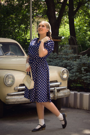 Beautiful lady in vintage dress standing near retro carの写真素材