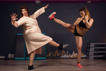 Athletic girl struggling with fat women. Same modelの写真素材