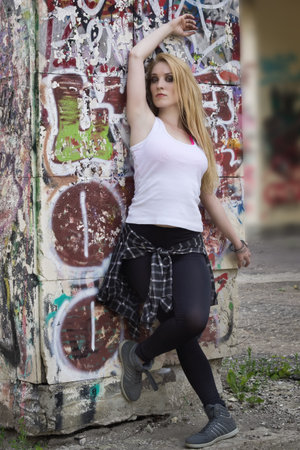 Young woman dancer on graffiti background. Dancing and urban culture concept.の写真素材