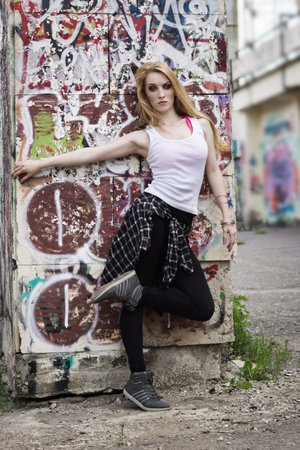 Young woman dancer on graffiti background. Dancing and urban culture concept.の写真素材
