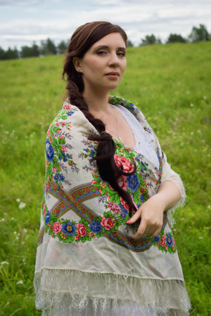 Russian woman in traditional clothes at wheat fieldの写真素材