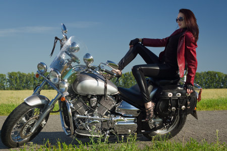 Sexy biker girl in a leather jacket on a motorcycleの写真素材