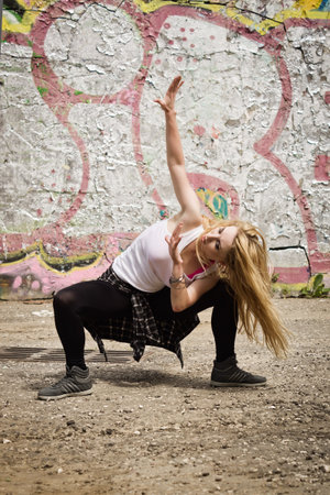 Young girl dancing on graffiti background. Dancing and urban culture concept.の写真素材