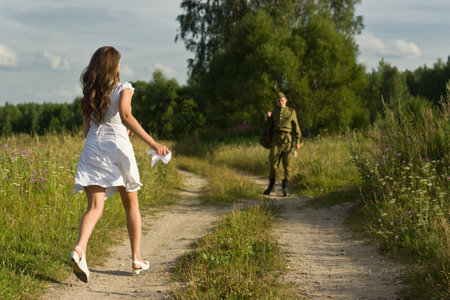 Happy girl meets a soldier. Return of the Soviet soldier in uniform of World War II homeの写真素材