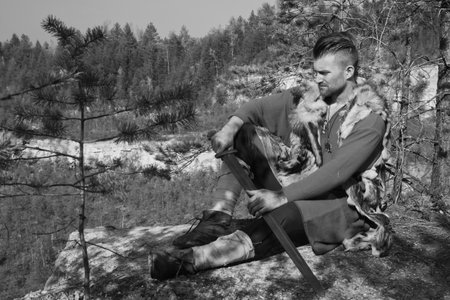 Male dressed in Barbarian style with sword in the mountainsの写真素材