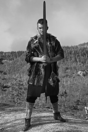 Male dressed in Barbarian style with sword in the mountainsの写真素材