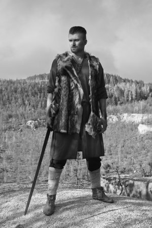 Male dressed in Barbarian style with sword in the mountainsの写真素材