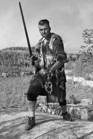 Viking attacking with a sword in the mountains