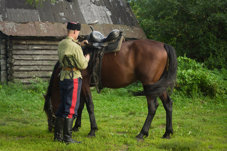 Russian Cossack and a horse resting in the summer field