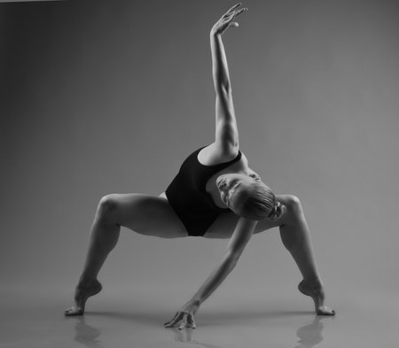 Young modern ballet dancer posing on dark backgroundの写真素材