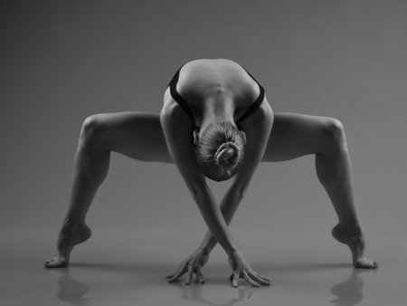 Young modern ballet dancer posing on dark backgroundの写真素材