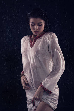 Brunette girl under water drops. Mysterious Night sceneの写真素材