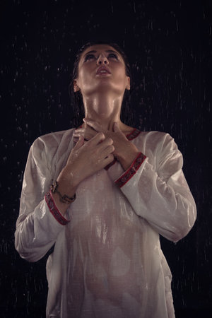Brunette girl under water drops. Mysterious Night sceneの写真素材