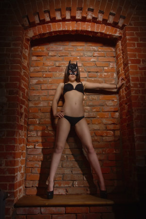 girl in the mask   against brick wall.の写真素材