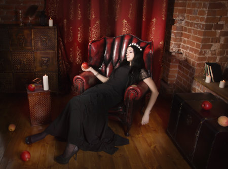 Gothic Snow White. Woman with poisoned apple in a tombの写真素材