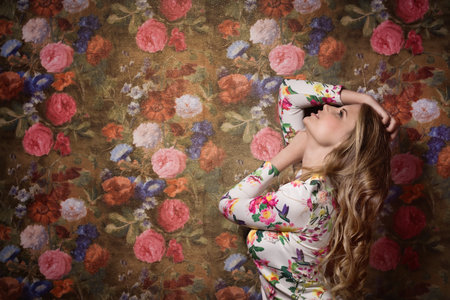 Portrait of the beautiful sensuality girl on a flower wall backgroundの写真素材