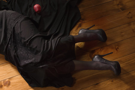 Gothic Snow White. Woman with poisoned apple lies on the floorの写真素材