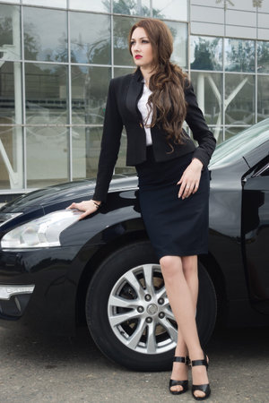 Successful business woman standing in the street background carの写真素材