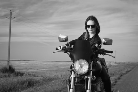 Sexy biker girl in a leather jacket on a motorcycleの写真素材