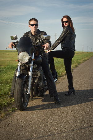 Biker man and girl stands on the road. Adventure concept.の写真素材