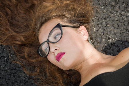 A Pretty young girl laying on asphaltの写真素材