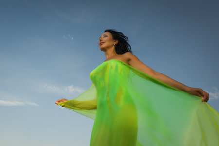 Beautiful adult woman in bikini and with pareo on a sky backgroundの写真素材