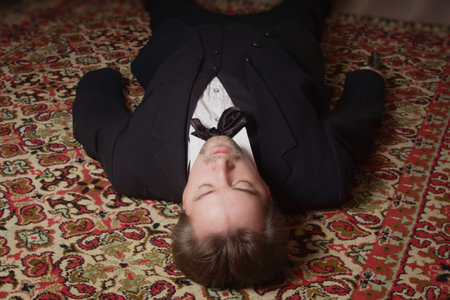 Corpse of killed business man lying on a floor in a bedroomの写真素材