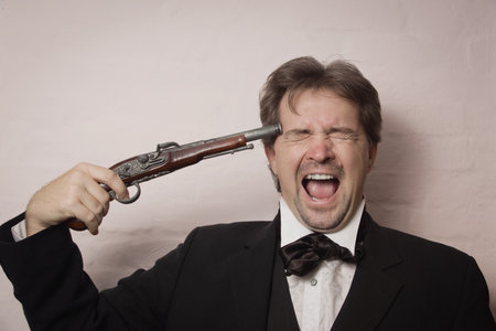 Victorian style man in a black suit shooting himselfの写真素材