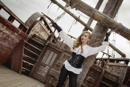 Fashion portrait of sexy woman in pirate style with old handgunの写真素材