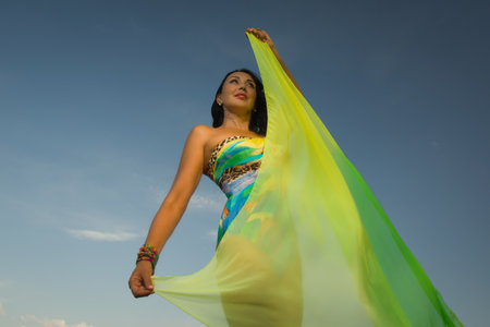 Beautiful adult woman in bikini and with pareo on a sky backgroundの写真素材