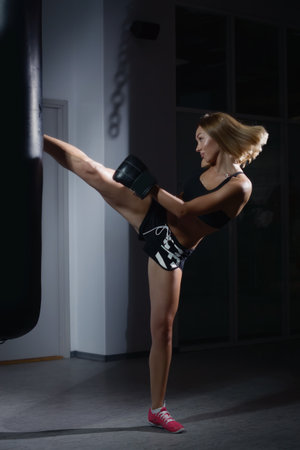 Young beautiful sexy boxer woman making kickの写真素材