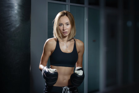 Young beautiful sexy boxer woman training kick boxing