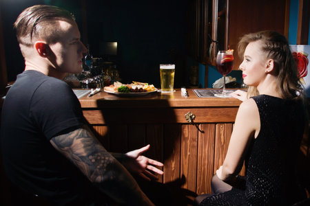 Smiling couple drinking beer in a barの写真素材