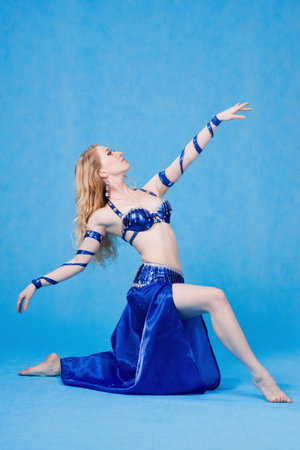 Beautiful belly dancer in a blue suit dance in motionの写真素材