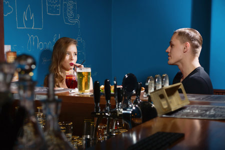 Smiling couple drinking beer in a barの写真素材