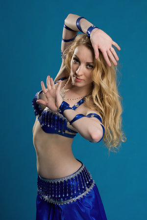 Beautiful belly dancer in a blue suit dance in motionの写真素材