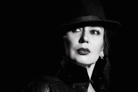 Elegant fashionable adult woman wearing black suit and hatの写真素材