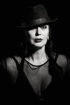 Elegant fashionable adult woman wearing black suit and hatの写真素材