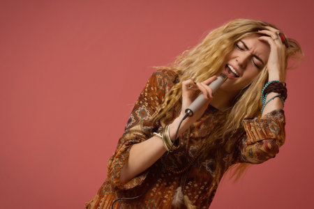 Rock star singing into a microphone. Hippie girl.の写真素材