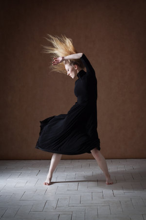 Young modern ballet dancer posing on dark backgroundの写真素材