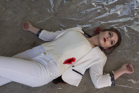 Noir film style. Crime scene with stabbed fashion woman in a darkplaceの写真素材
